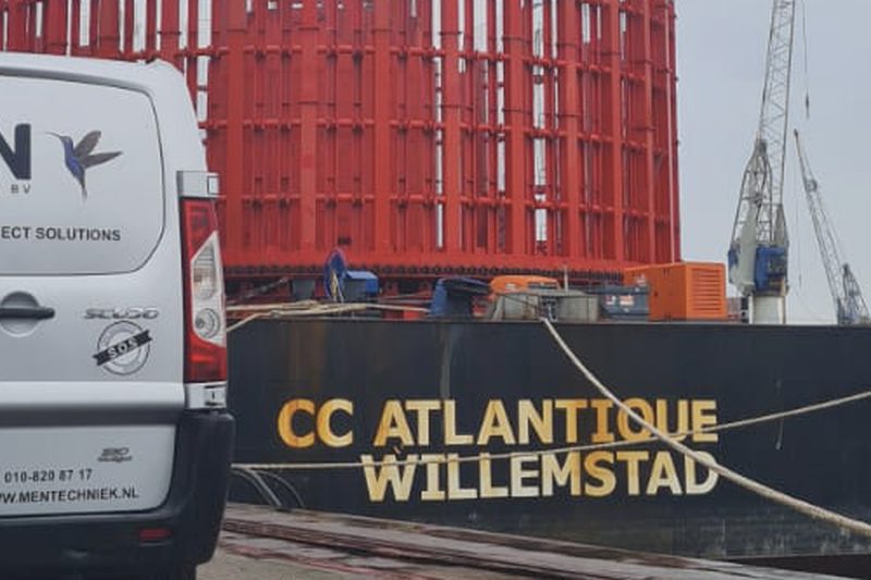 Servicebus van MEN Techniek langs een zeeschip in de haven